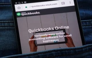 QuickBooks Online shown on a smartphone highlights key differences in cleaning up QuickBooks Online vs Desktop for Denver businesses using DK/RK Services.