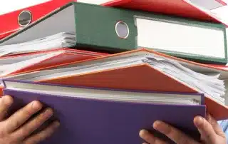 How bookkeeping consultancy helps e commerce businesses scale, shown with an image of a person holding a stack of colorful binders.v