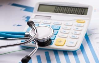 Stethoscope and calculator on financial documents.