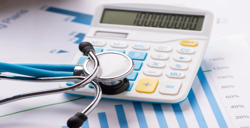 Stethoscope and calculator on financial documents.