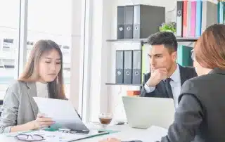 Why service based businesses benefit from outsourced CFO services, with an image showing a team reviewing documents in a modern office.